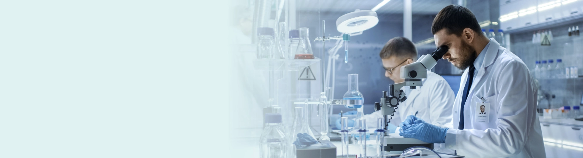 Natural Pharmaceuticals Hepactum™ FORTE Egy tudós a laboratóriumban mikroszkópon keresztül néz.