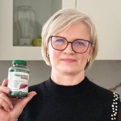 Natural Pharmaceuticals Hepactum™ FORTE Žmogus juodu megztiniu šypsosi ir atsiremia į medį lauko gamtoje rudens metu.