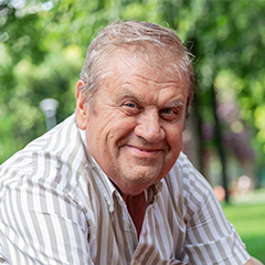 Natural Pharmaceuticals Hepactum FORTE Mosolygó középkorú férfi fehér csíkos ingben zöld parkban, napfényes időben.